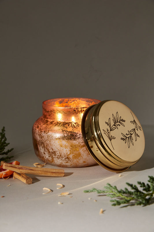 Enchanted Forest Candle in gold glass container with etched lid open and lighted