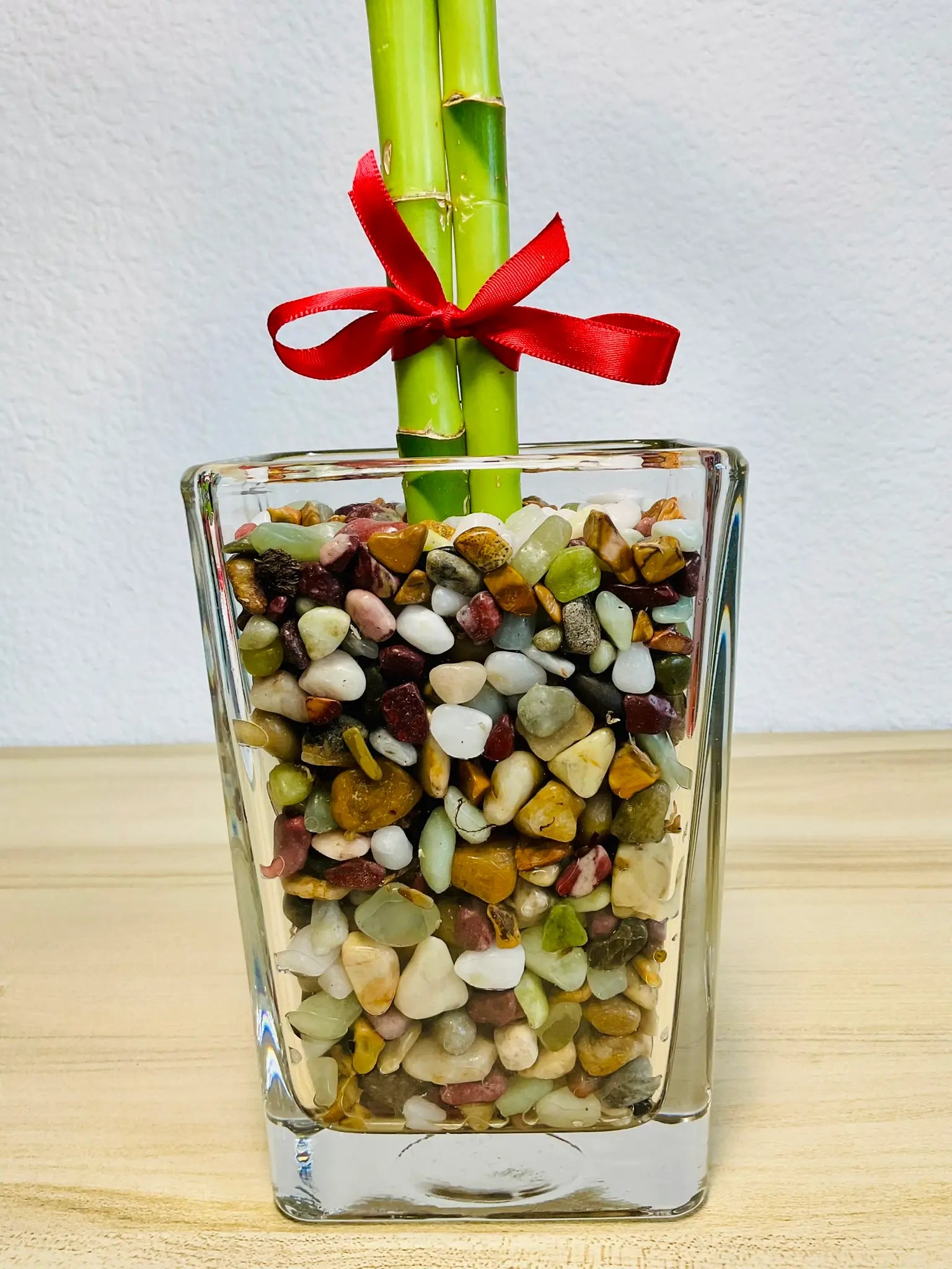 Heart-shaped single lucky bamboo stalk and pebbles up close